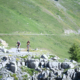 ciclisti su strada di montagna in provincia di Cuneo, valle Grana, colle Fauniera. Ambiente roccioso e verde.