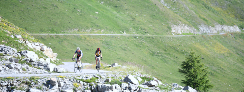 ciclisti su strada di montagna in provincia di Cuneo, valle Grana, colle Fauniera. Ambiente roccioso e verde.